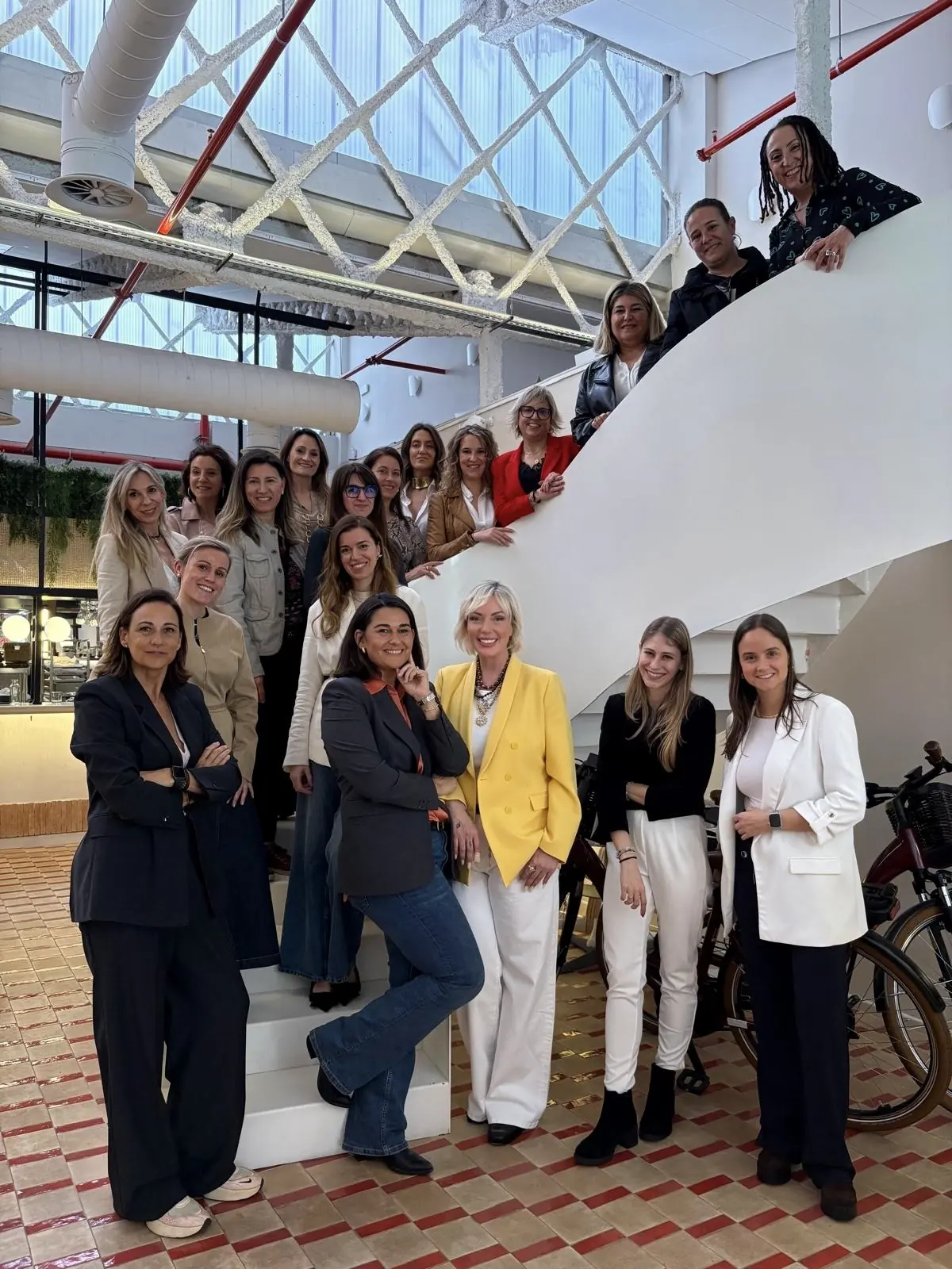 Group photo of the women attending an IKONIKAS gathering on a white staircase