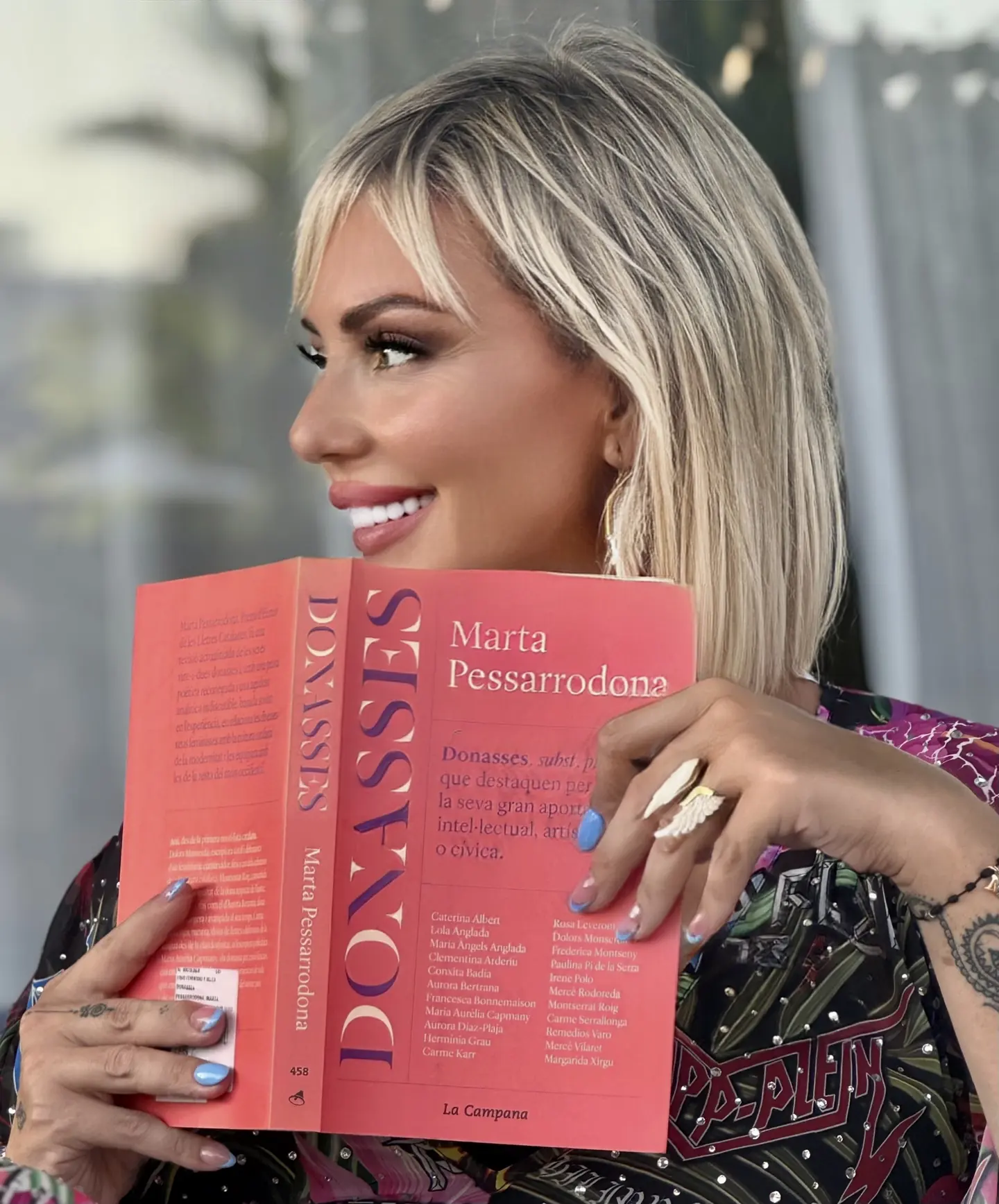 Meritxell Bautista holding the book “Donasses” by Marta Pessarrodona